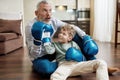 Grandfather and his little excited grandson wearing boxing gloves playing and imitating punches, having fun together at Royalty Free Stock Photo