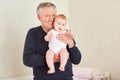 Grandfather holding a baby in her hands. Royalty Free Stock Photo