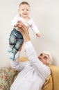 Grandfather holding grandson while sitting on sofa Royalty Free Stock Photo