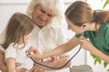 Grandfather holding his small granddaughter while she is being examined by docto Royalty Free Stock Photo