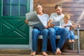 Grandfather with a newspaper, son with a tablet, grandson with a smartphone are sitting on a bench Royalty Free Stock Photo