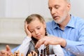 Grandfather playing chess with little girl