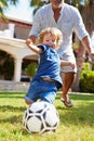 Grandfather Playing Football With Grandson In Garden Royalty Free Stock Photo