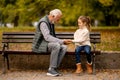 Grandfather playing red hands slapping game with his granddaughter in park on autumn day Royalty Free Stock Photo