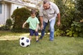 Grandfather Playing Soccer In Garden With Grandson Royalty Free Stock Photo