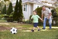 Grandfather Playing Soccer In Garden With Grandson Royalty Free Stock Photo