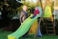 Grandfather plays with granddaughter on playground Royalty Free Stock Photo