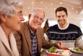 Grandfather, portrait and family at dinner on Christmas together with food and celebration in home. Happy, event and old