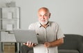 Grandfather, portrait of senior man with a laptop. Senior man with a gray beard at home. Mature man using computer. Royalty Free Stock Photo