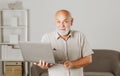 Grandfather, portrait of senior man with a laptop. Senior man with a gray beard at home. Mature man using computer.