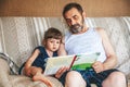 Grandfather reading a book to his granddaughter