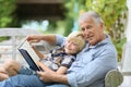 Grandfather reading bookstory to little boy