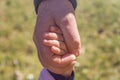 Grandfather`s hand holding granddaughter`s hand. with soft light