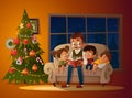 Grandfather sitting with grandchildren on a cozy sofa with the book, near Christmas tree. Reading and telling book fairy