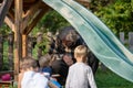 Grandfather sitting under a slide playing with his grandchildren