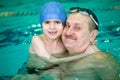 Grandfather with small boy in swimming pool