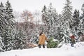 Grandfather and small girl getting a Christmas tree in forest.