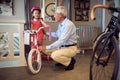 Grandfather and child choosing bicycle in bike shop