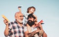 Grandfather with son and grandson having fun in park. Fathers day concept. Cute child hugging his father and grandfather