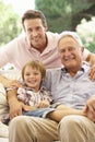 Grandfather With Son And Grandson Laughing Together On Sofa Royalty Free Stock Photo
