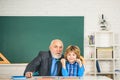 Grandfather and son having fun together. Happy grandson and Grandfather sitting at a desk indoors. Back to school Royalty Free Stock Photo
