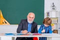 A grandfather and a son are learning in class. Student and tutoring education concept. Back to school. Old and Young Royalty Free Stock Photo