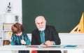 A grandfather and a son are learning in class. Student and tutoring education concept. Back to school. Old and Young Royalty Free Stock Photo