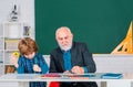 A grandfather and a son are learning in class. Student and tutoring education concept. Back to school. Old and Young Royalty Free Stock Photo