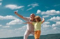 Grandfather and son playing with paper plane over blue sky and clouds background. Royalty Free Stock Photo