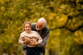 Grandfather playing red hands slapping game with his granddaughter in park on autumn day Royalty Free Stock Photo