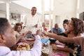 Grandfather standing to make a speech at the table with his family, close up