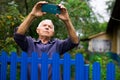 Grandfather takes selfie in front of his country house in village