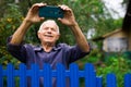 Grandfather takes selfie in front of his country house in village