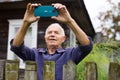 Grandfather takes selfie in front of his country house in village