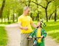 Grandfather talking with his grandson riding a bicycle and showing thumbs up Royalty Free Stock Photo