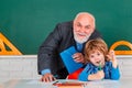 Grandfather teacher with grandson pupil at back of classroom at the elementary school. Science education concept. Royalty Free Stock Photo