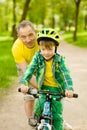 Grandfather teaches his grandson to ride a bike Royalty Free Stock Photo