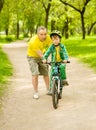 Grandfather teaches his grandson to ride a bike Royalty Free Stock Photo