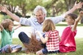 Grandfather Teaching Grandchildren To Build Camp Fire