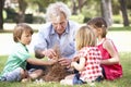 Grandfather Teaching Grandchildren To Build Camp Fire Royalty Free Stock Photo