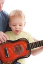 Grandfather teaching grandson play on guitar