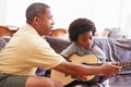 Grandfather Teaching Grandson To Play Guitar