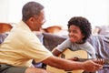 Grandfather Teaching Grandson To Play Guitar