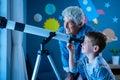 Grandson with grandfather stargazing at night with a telescope Royalty Free Stock Photo