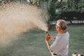 Grandfather water the plants in garden alone. Retirement age lifestyle at home