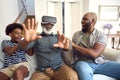 Grandfather Wearing VR Headset As Multi-Generation Male Family Sit On Sofa At Home Together Royalty Free Stock Photo