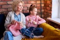 Grandma and child girl knitting. Senior woman teaching little girl to knit.