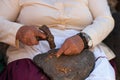 Grandma cracking nut almond shells with a hammer