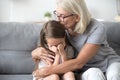 Grandma embrace frustrated granddaughter sitting on couch Royalty Free Stock Photo