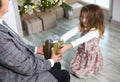 Grandma gives her granddaughter a gift for Christmas. The girl stretches out her hands to the box with the bow. New year, family h Royalty Free Stock Photo